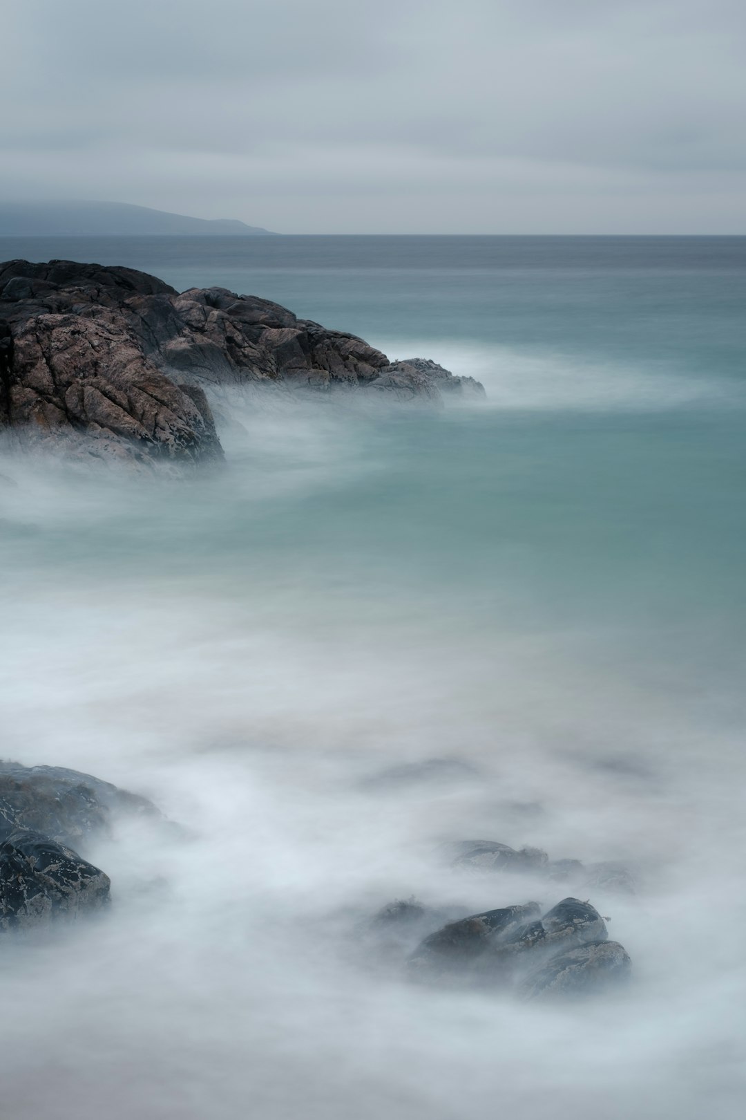 ocean waves crashing on brown rock formation during daytime