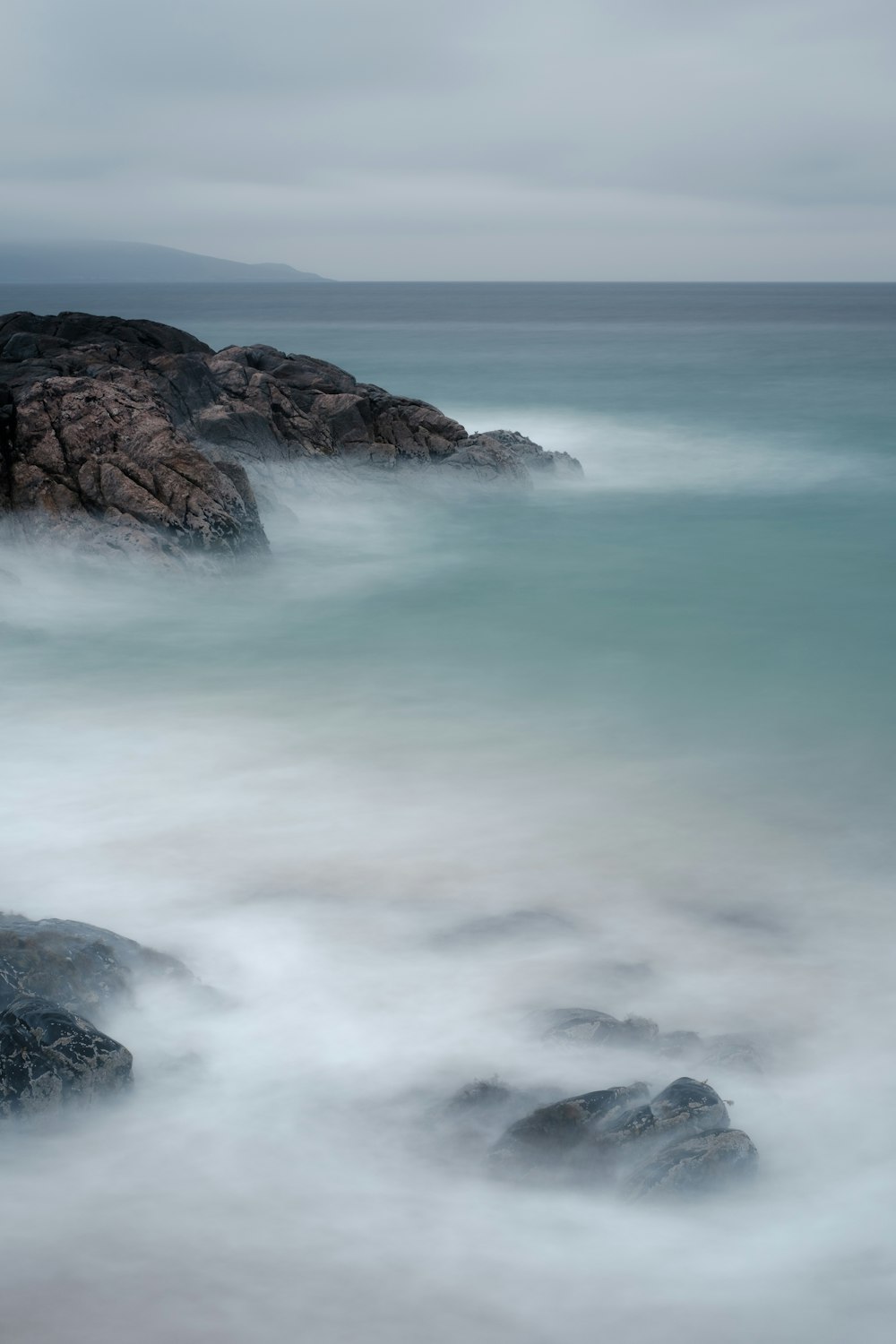 Les vagues de l’océan s’écrasent sur la formation de roche brune pendant la journée