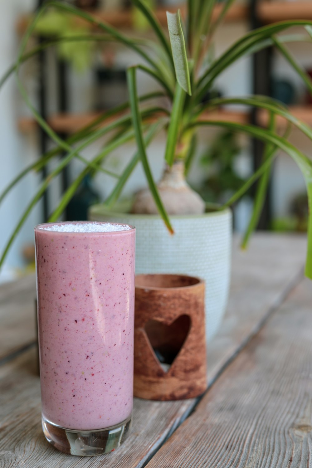 Vela de pilar rosa sobre mesa de madera marrón