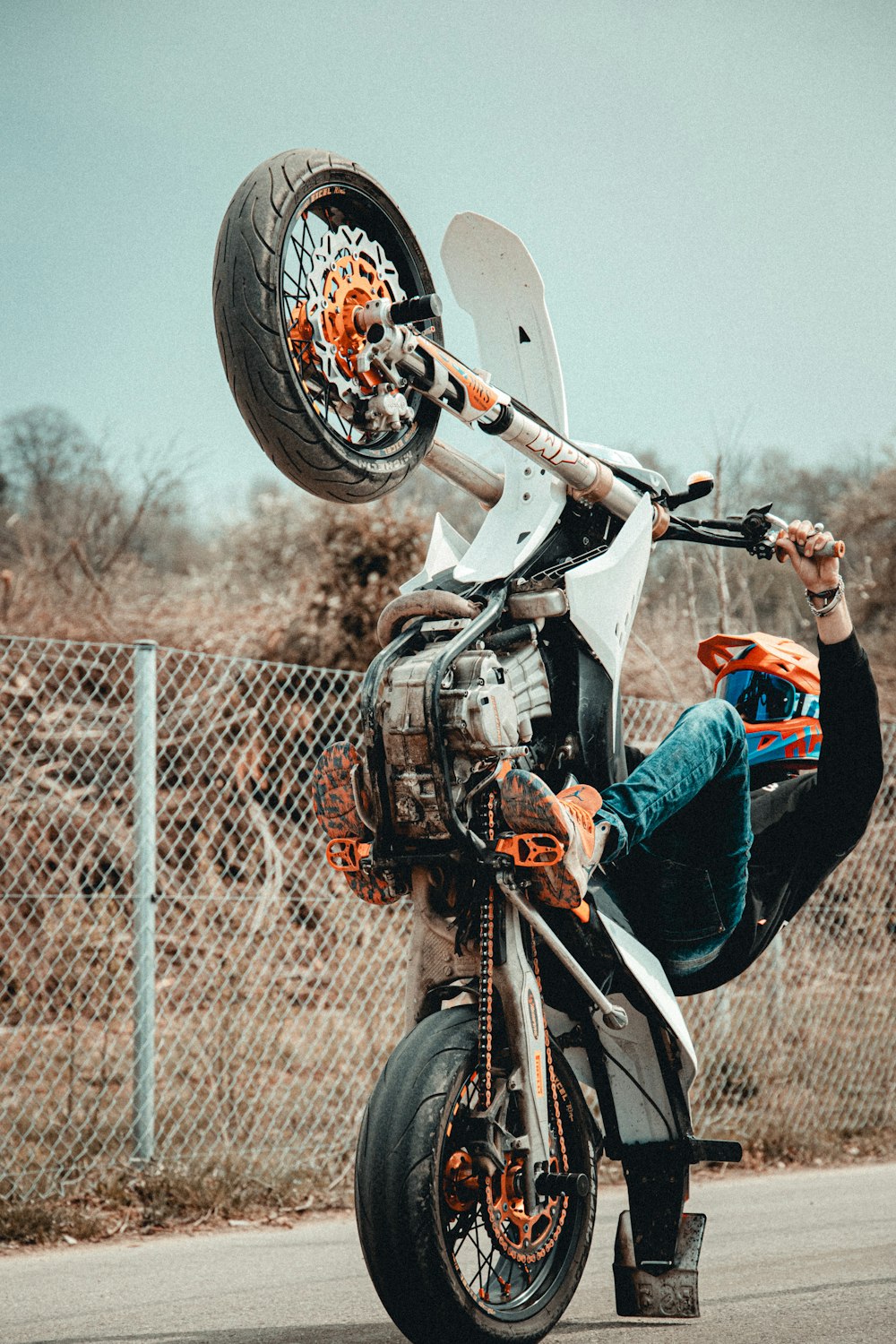 man in white long sleeve shirt and blue denim jeans riding on motorcycle during daytime