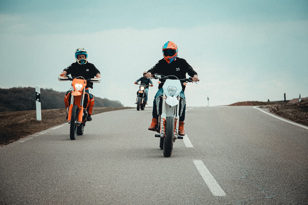 3 men riding motorcycle on road during daytime