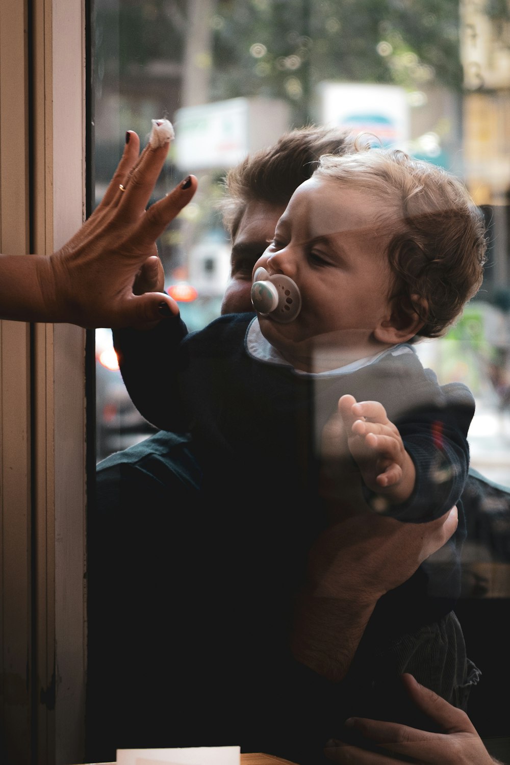 boy in black crew neck t-shirt holding white framed glass window