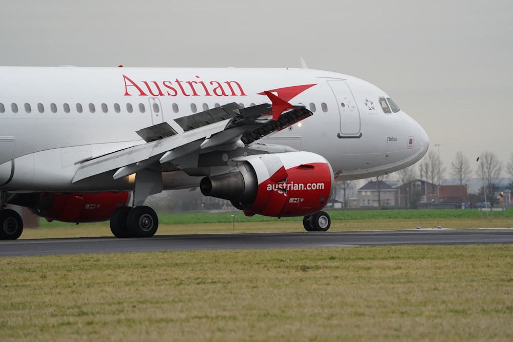 white and red passenger plane on airport during daytime