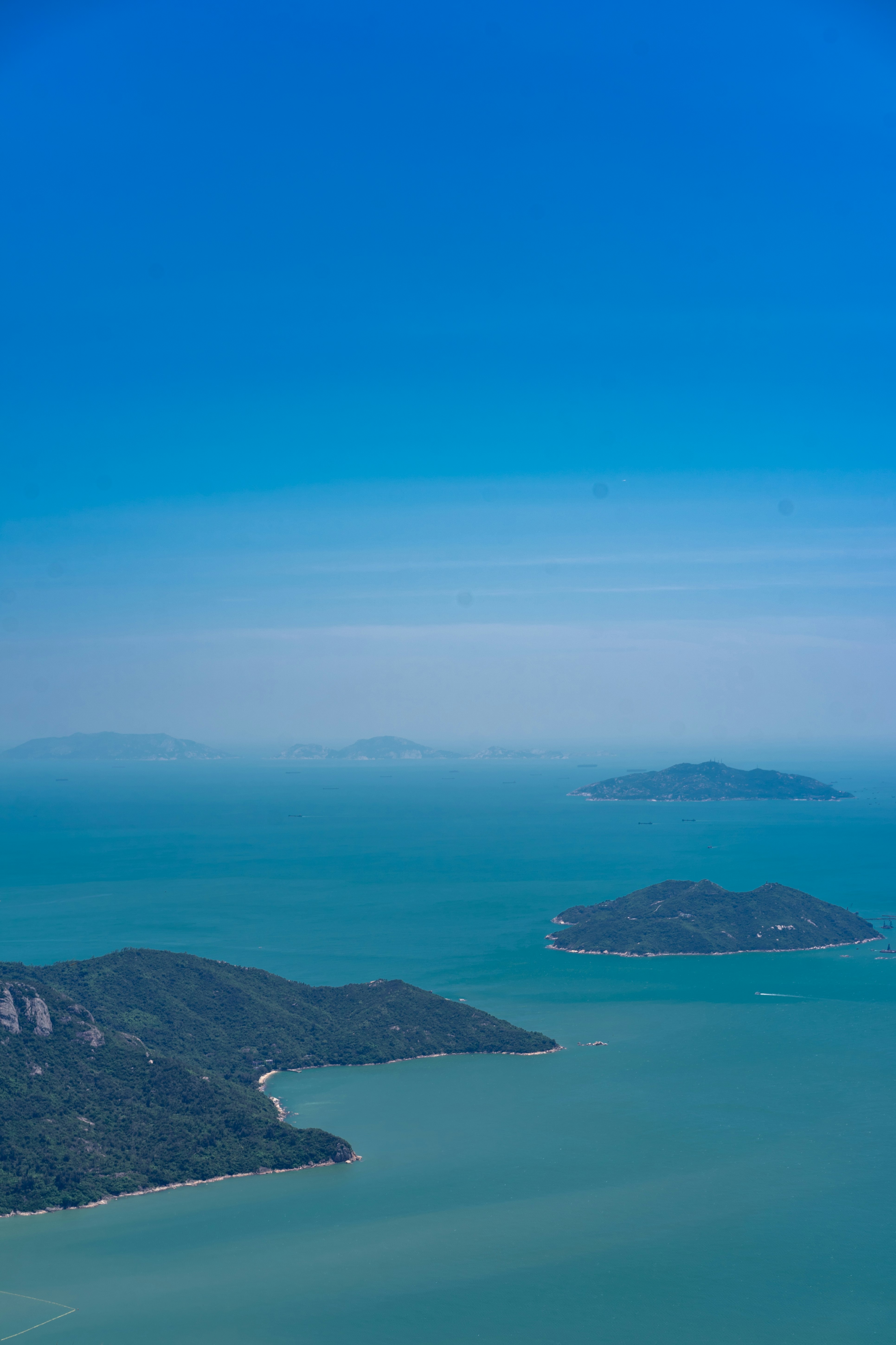 green mountain beside blue sea under blue sky during daytime