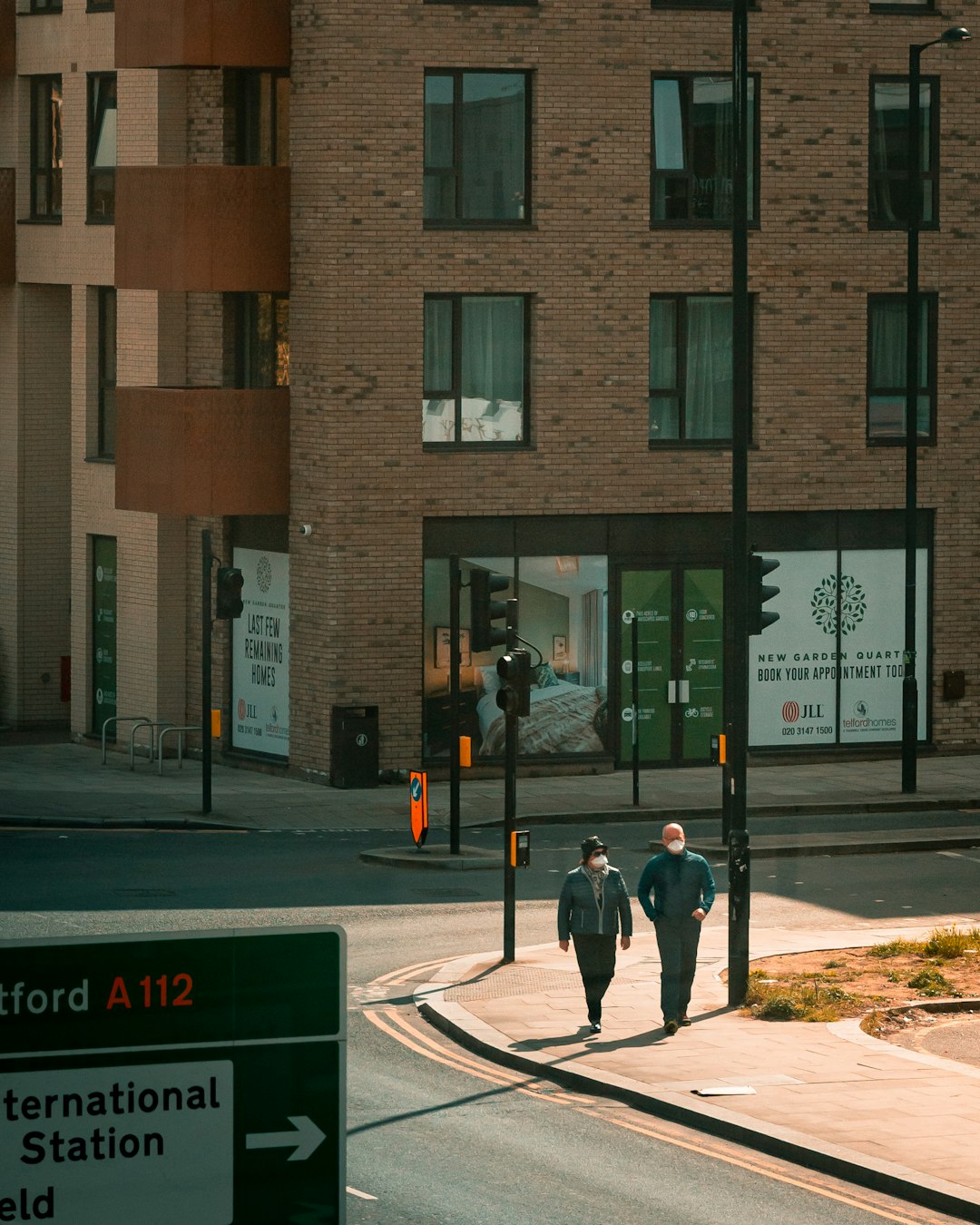 man in black jacket and black pants standing near brown concrete building during daytime