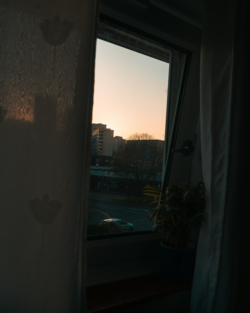 white framed glass window with view of city buildings during daytime