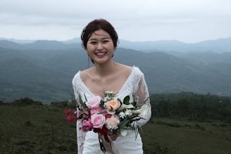 woman in white floral lace long sleeve shirt holding bouquet of flowers