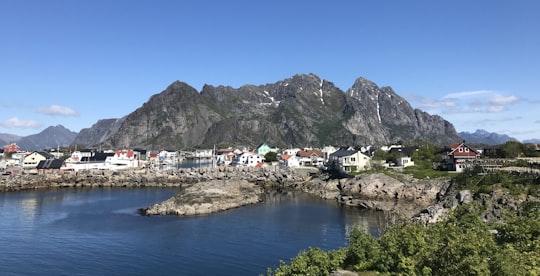white and brown houses near body of water and mountain during daytime in Henningsvær Norway