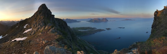 green and brown mountain beside body of water during daytime in Svolvær Norway