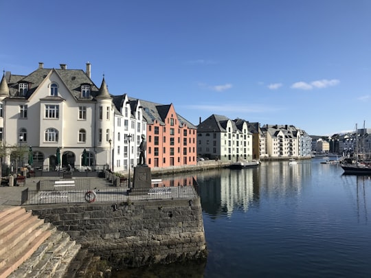 white and brown concrete building near body of water during daytime in Ålesund Norway