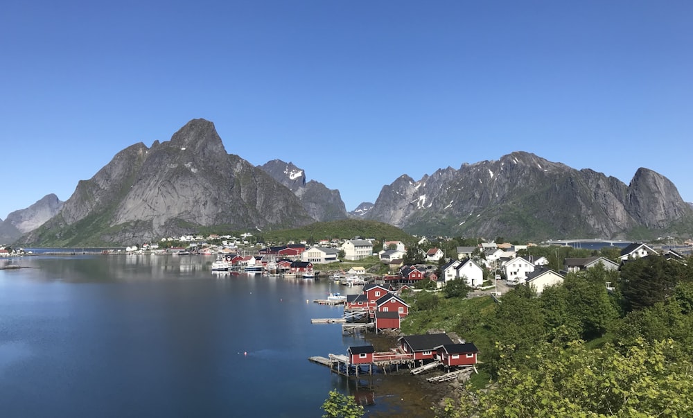 昼間の湖や山の近くの家