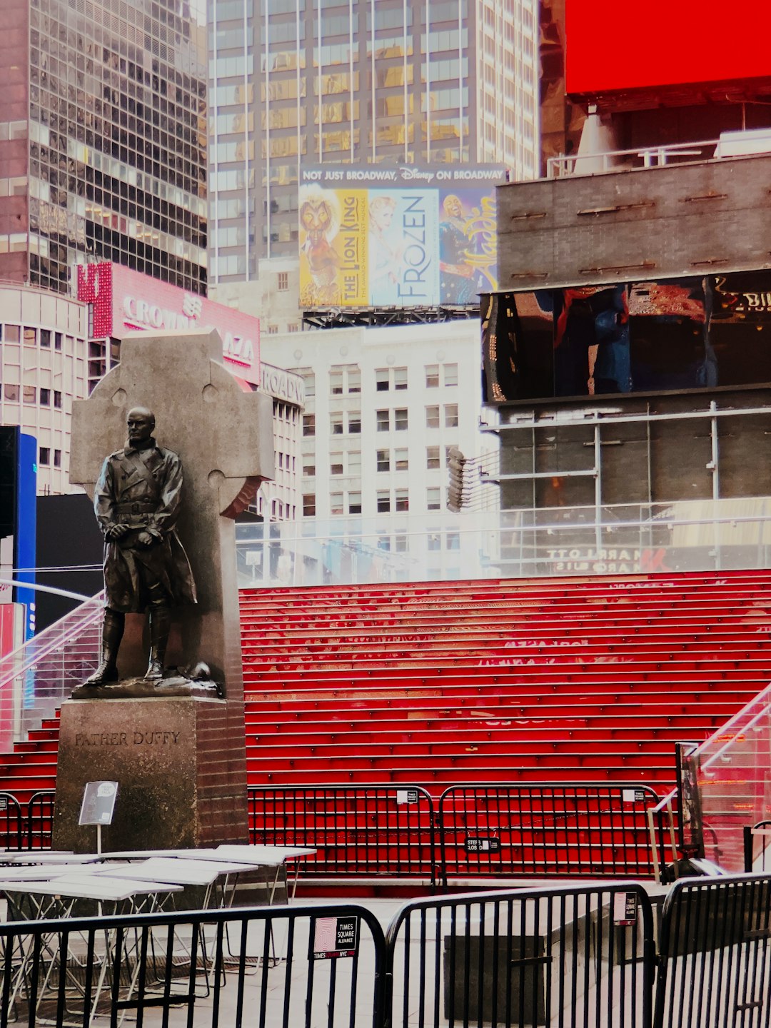 man in black jacket statue near red and white train during daytime