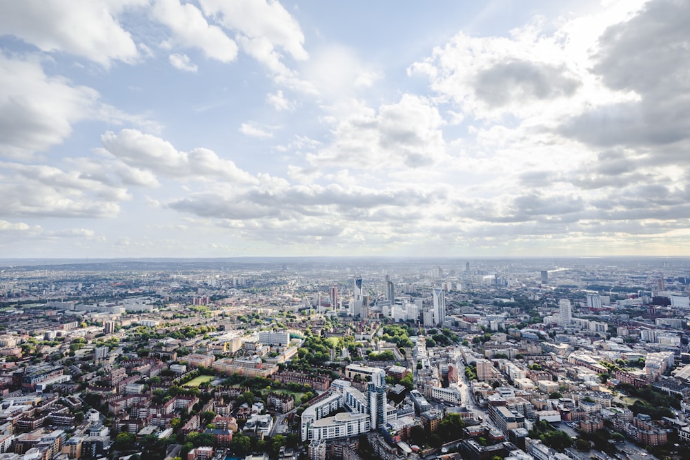 city buildings under white clouds and blue sky during daytime