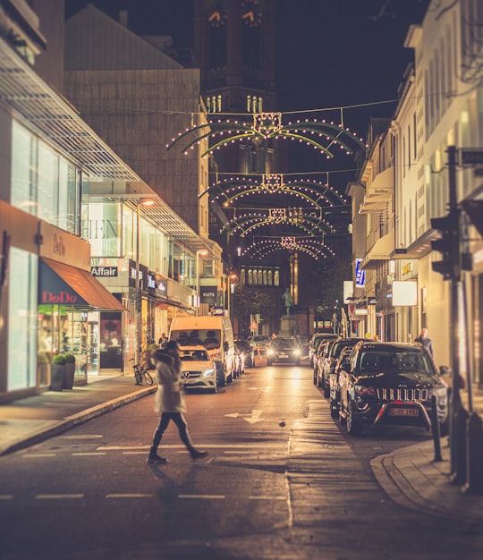 people walking on sidewalk during night time in Düsseldorf Germany
