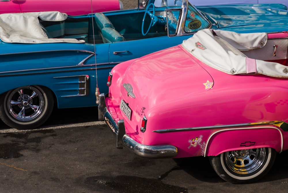 pink chevrolet car parked beside blue car