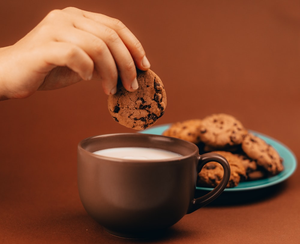 person holding white ceramic mug with coffee