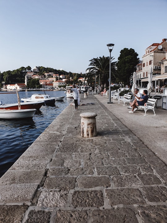 people sitting on bench near body of water during daytime in Cavtat Croatia