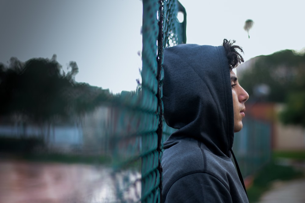 person in black hoodie holding blue rope