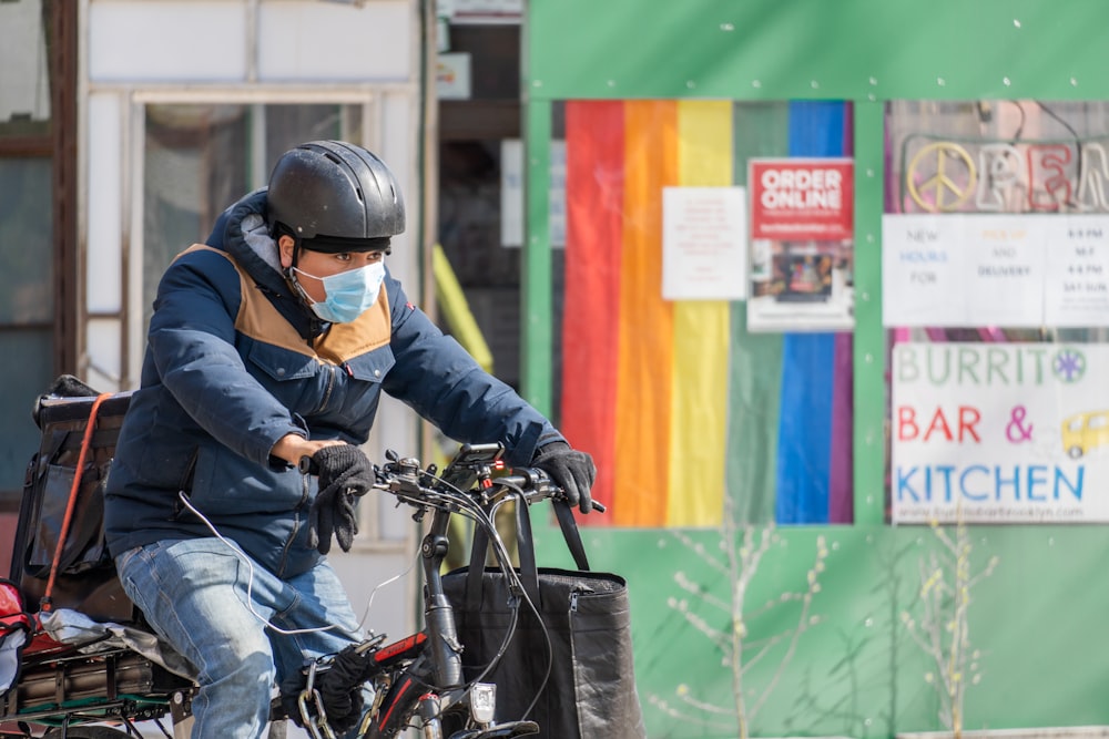 man in black jacket riding on black bicycle