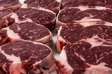 High-quality pork cuts neatly arranged in a professional industrial kitchen setting.