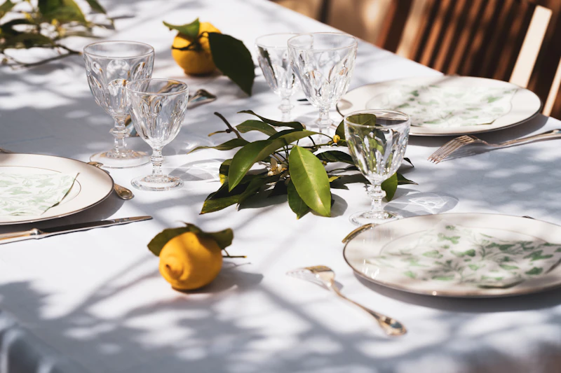 A table set with plates and crystal glasses in sunlight