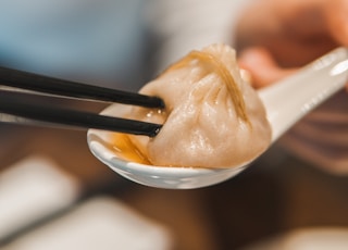 person holding white ceramic bowl with white cream