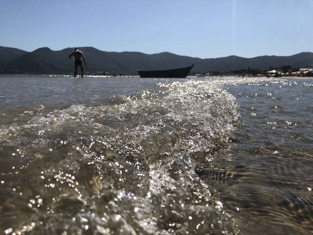 2 people standing on sea shore during daytime