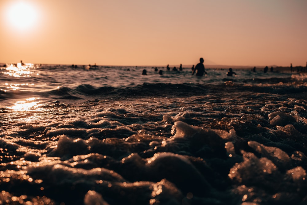 silhouette of 2 people walking on beach during daytime