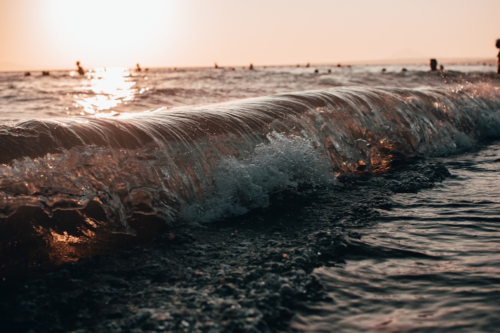 water waves on black sand during daytime