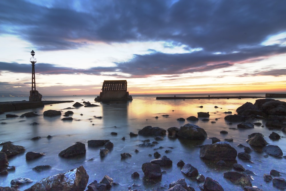 brown rocks on seashore during sunset