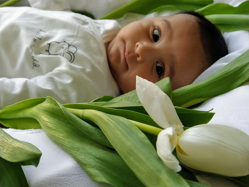 baby lying on white bed