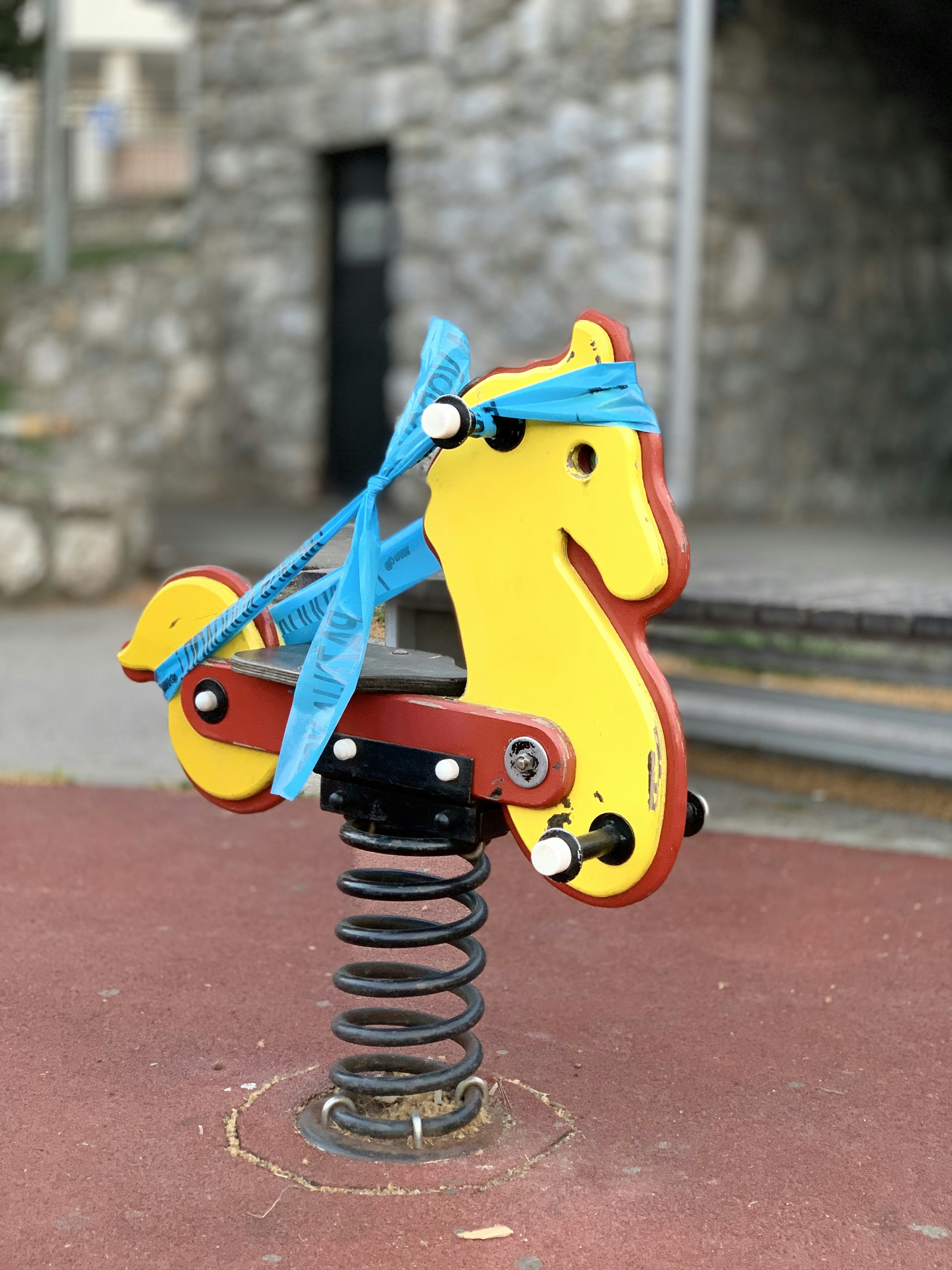 gelb-blaues Fahrrad mit blauem Gurt auf braunem Betonboden