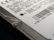 Close-up view of a hard drive with visible text and a barcode. The focus is on the details of the labeling, including technical specifications and a recognizable logo. The image captures the edge of the hard drive with a visible screw.