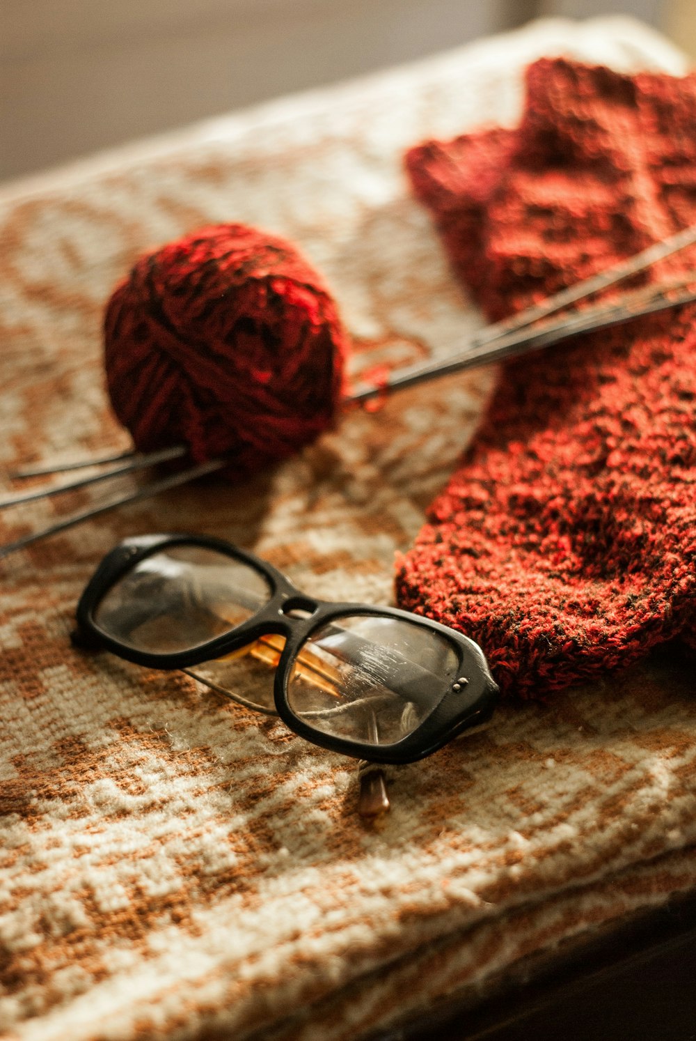 black framed eyeglasses on white and red textile