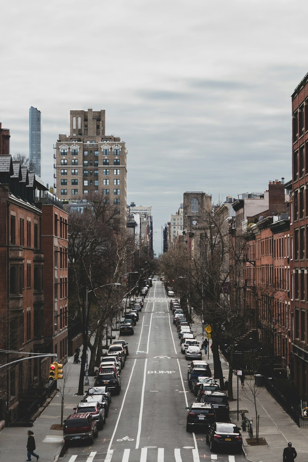 cars on road between high rise buildings during daytime