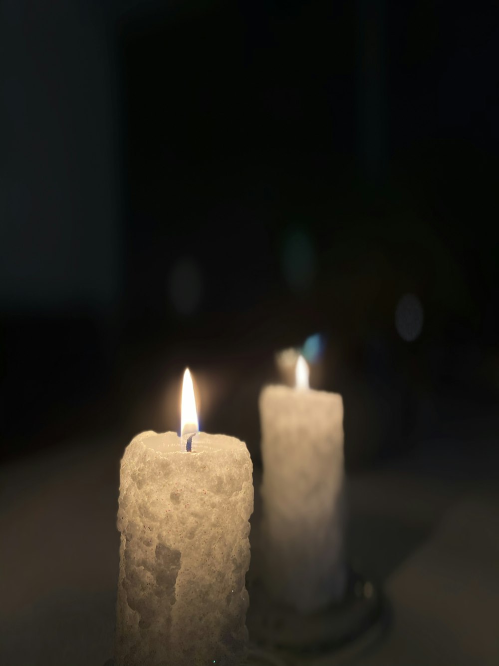 white pillar candle in dark room