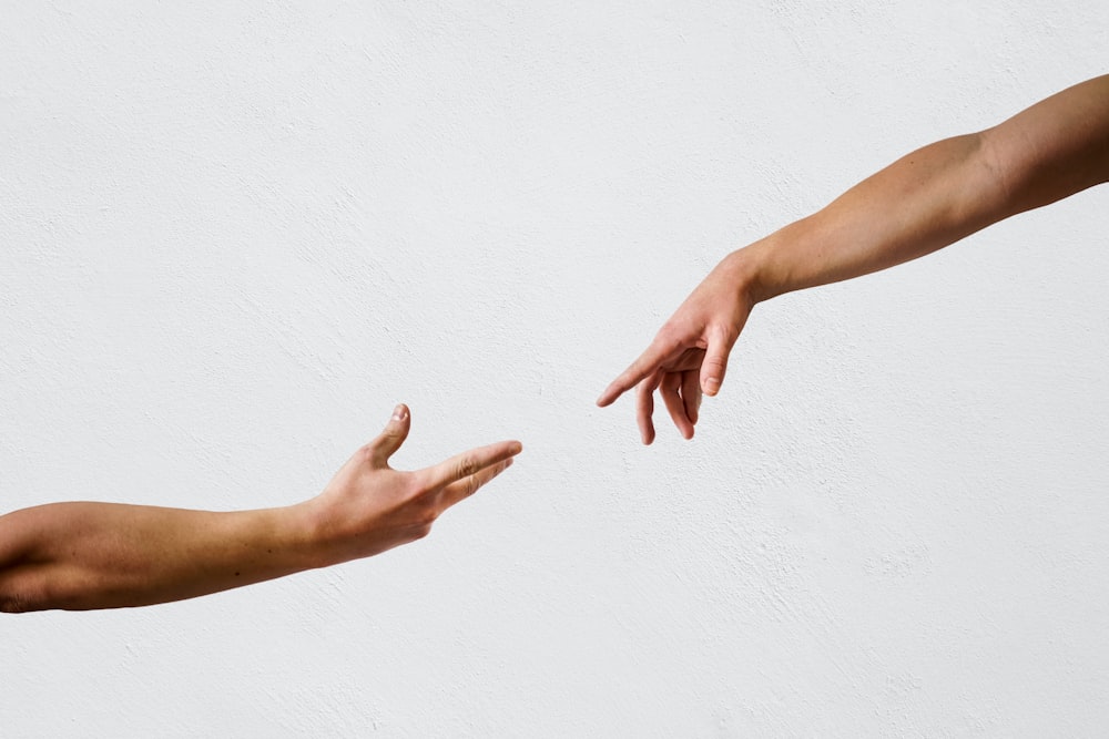 La mano de las personas en la pared blanca