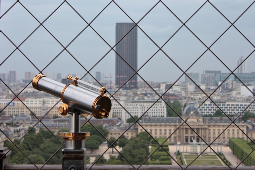gold and black telescope near city buildings during daytime