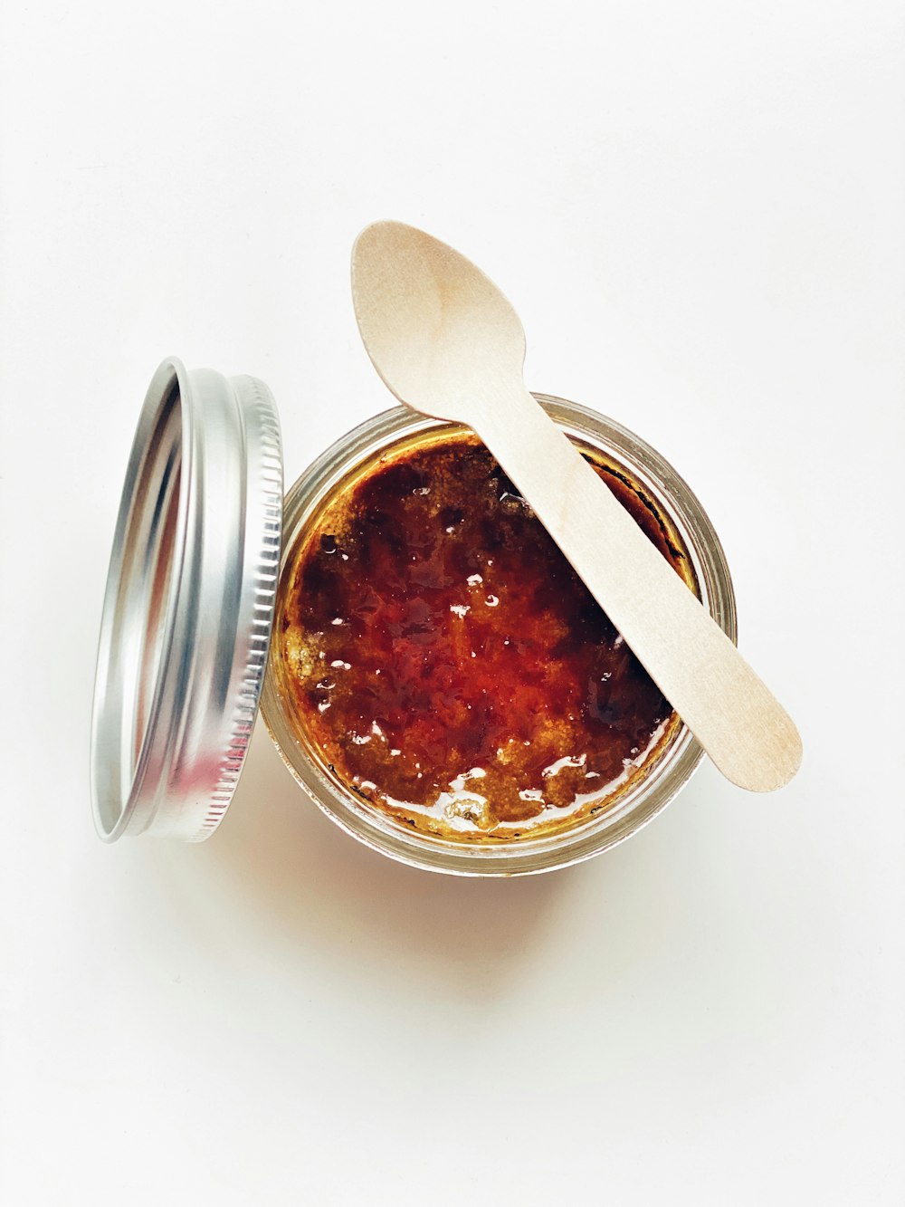 arial picture of marmalade in clear glass jar with spoom