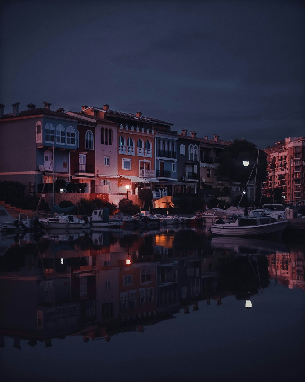 red and white concrete building beside body of water during night time