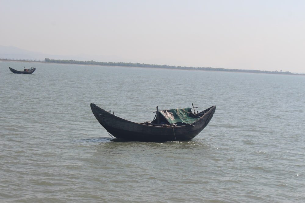 black boat on sea during daytime