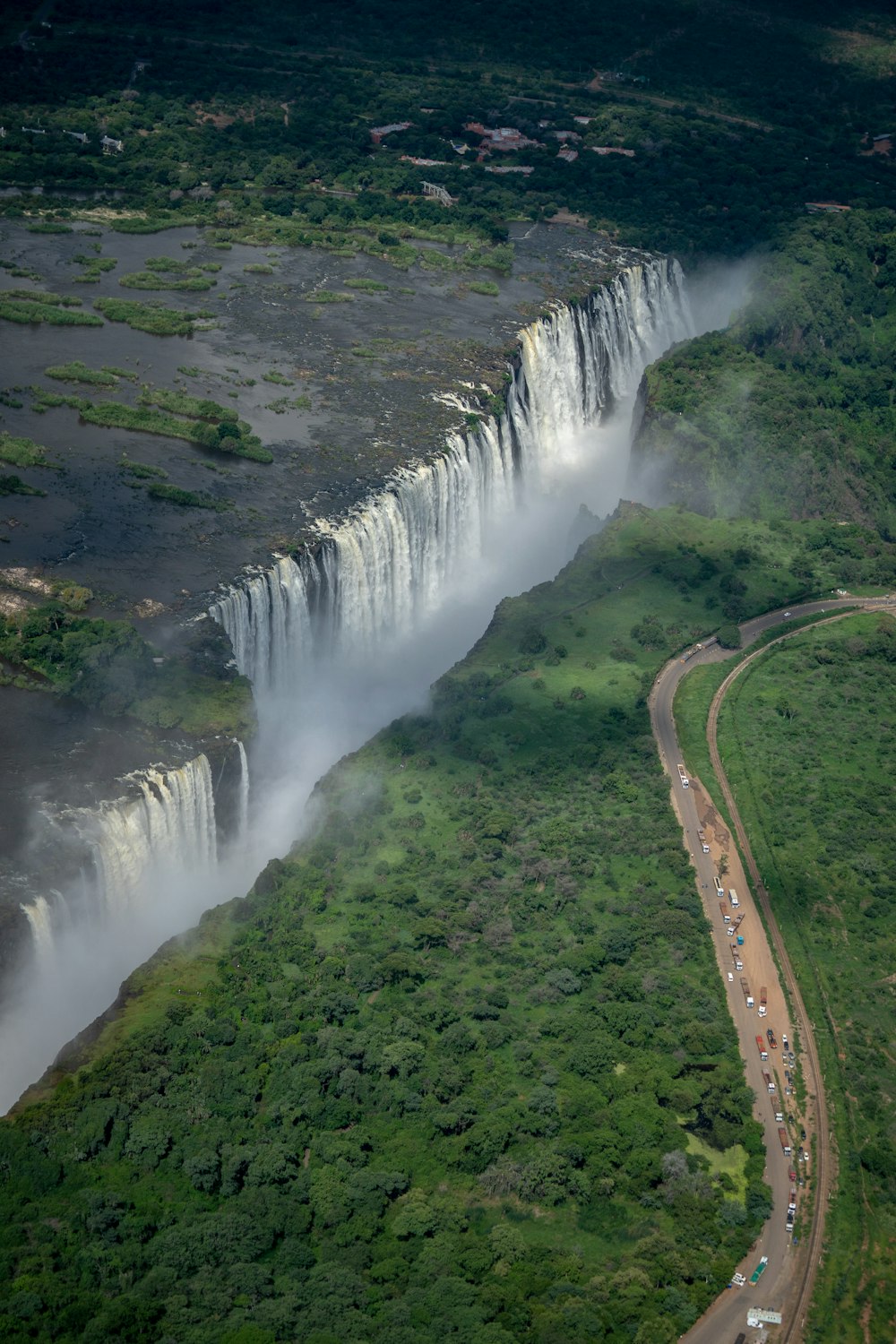 green grass and trees near waterfalls during daytime