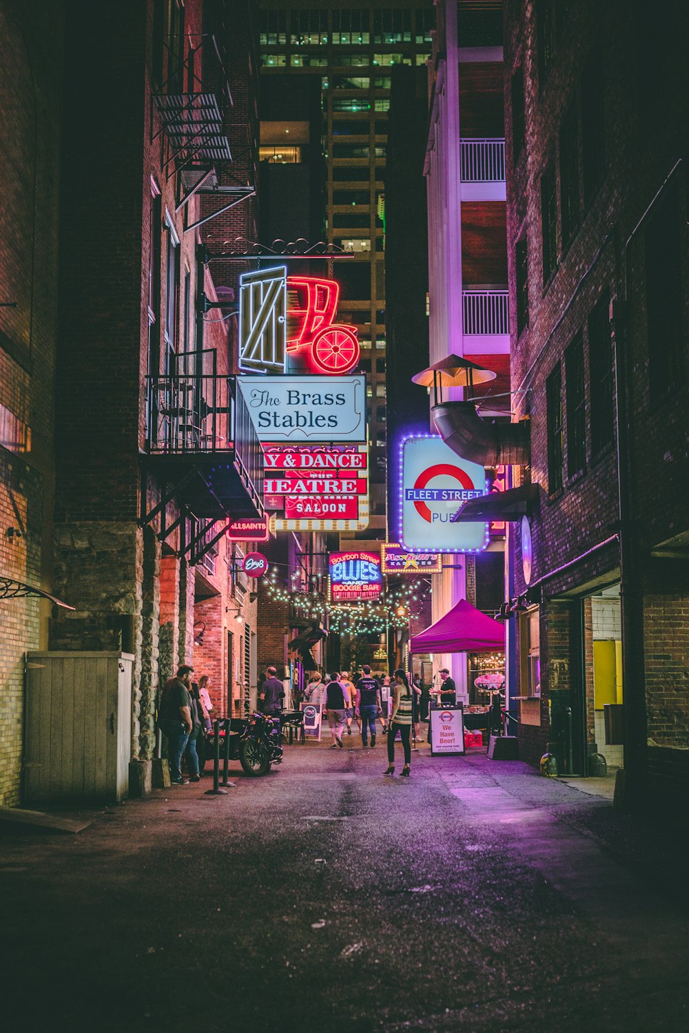 people walking on sidewalk near store during night time