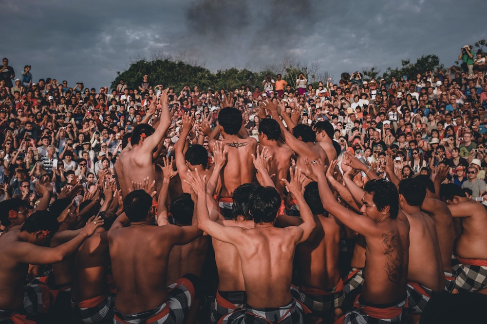 a group of men in bathing suits standing in front of a crowd