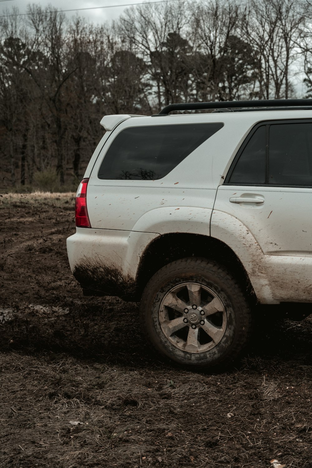 昼間の未舗装の道路に白いSUV