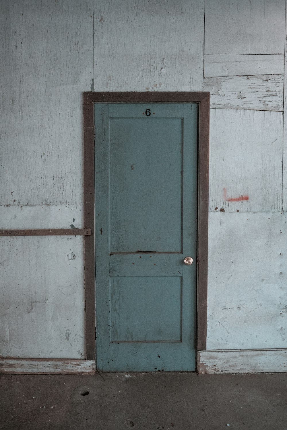 blaue Holztür an weiß gestrichener Wand