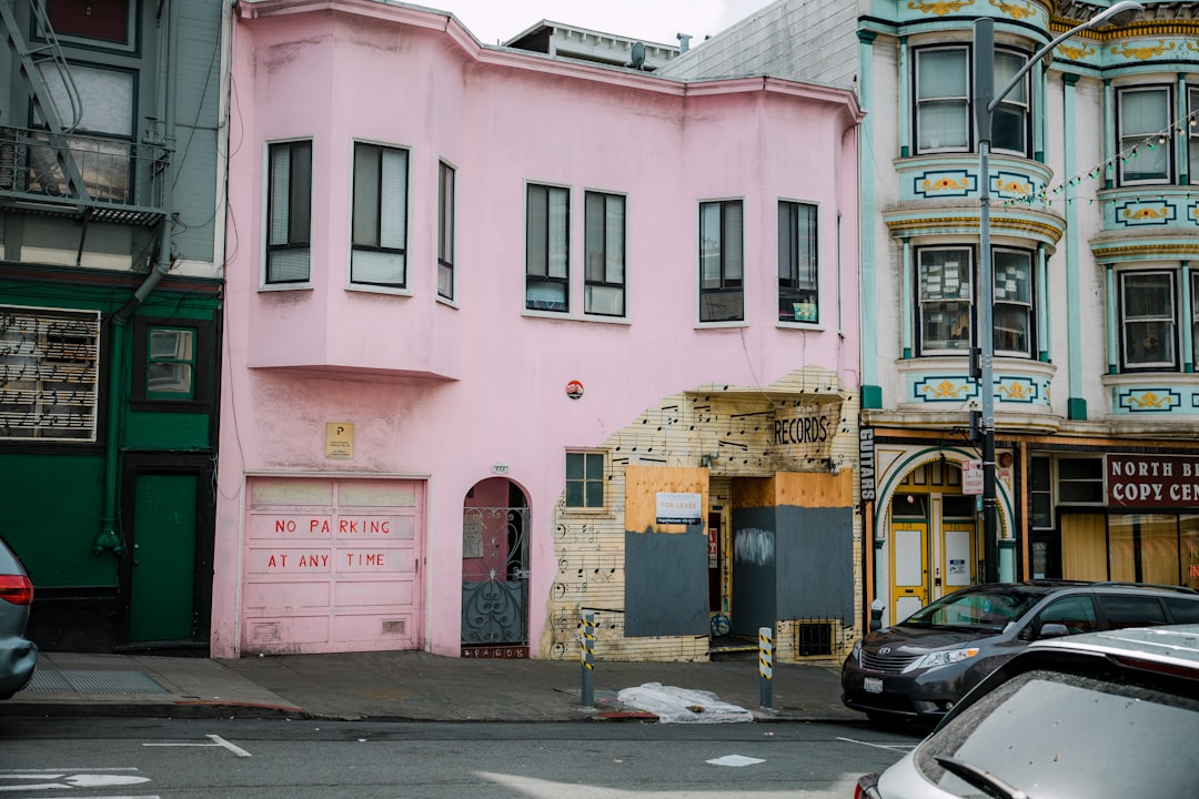 cars parked beside concrete building during daytime