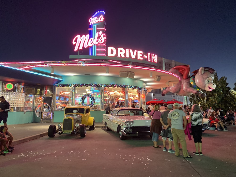 people standing near red and white UNKs store during night time