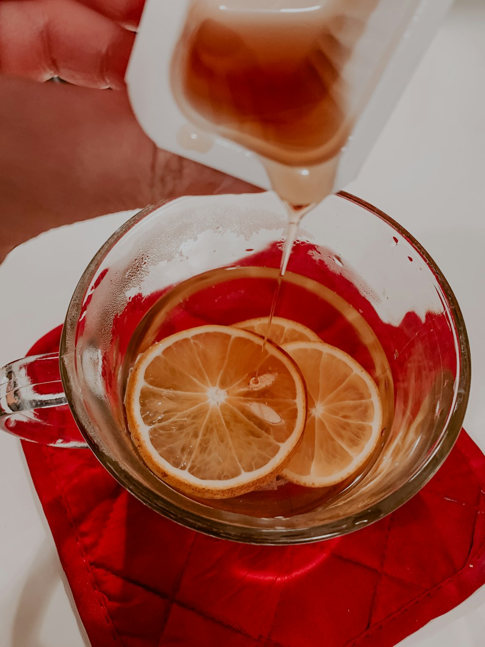 clear glass mug with brown liquid and sliced lemon