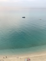 A peaceful beach scene at Dahab with turquoise waters and colorful boats resting on the shore.